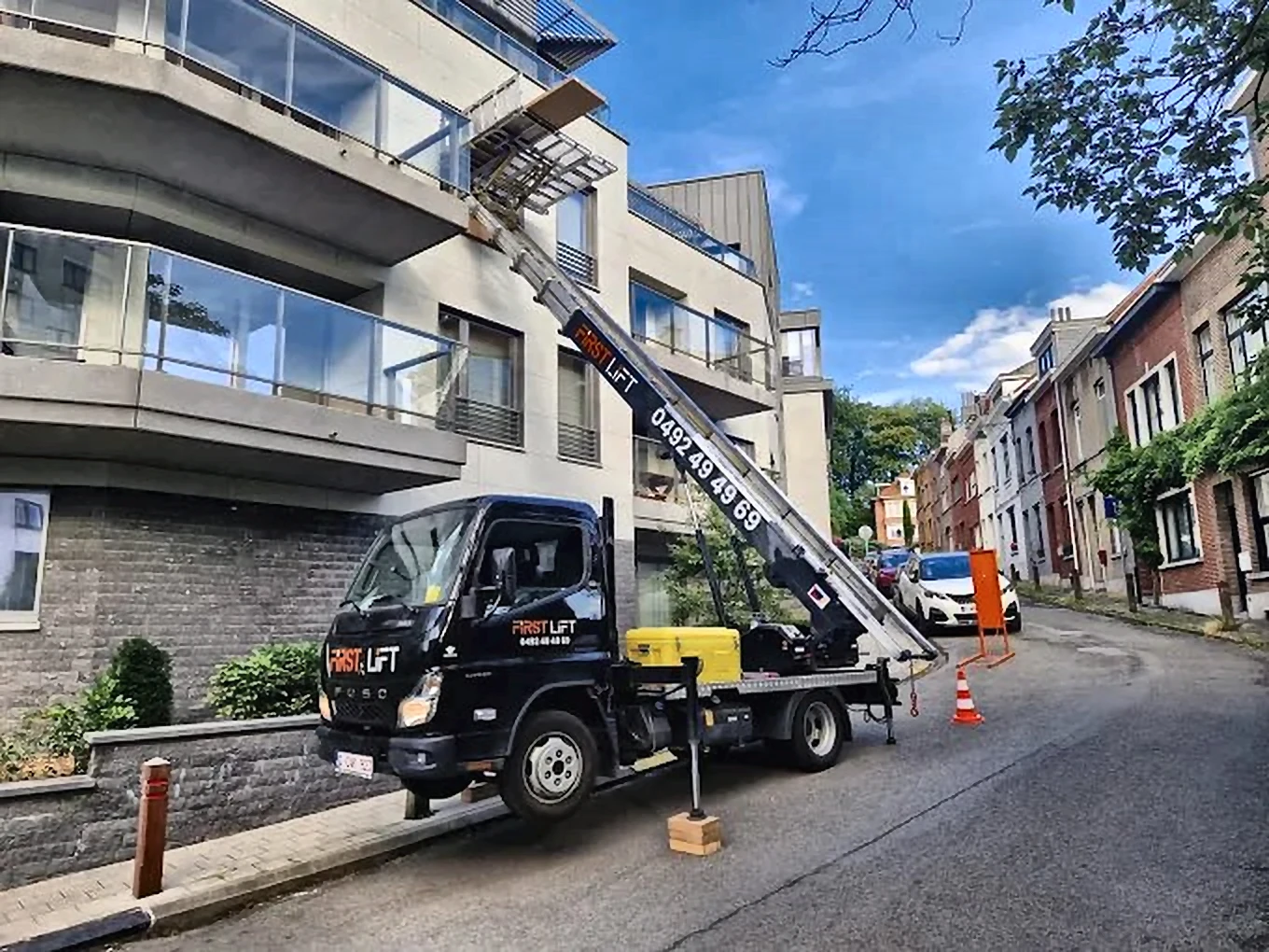 Camion FLS Moving avec lift en action sur un immeuble bruxellois